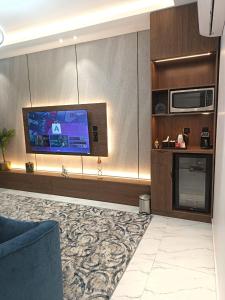 a living room with a flat screen tv and a couch at لافيرا هاوس in Taif