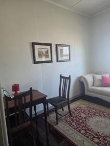 a living room with a table and a chair and a couch at The Gympie Empire in Gympie