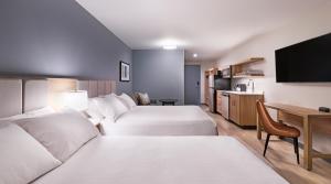a hotel room with two beds and a tv at Hyatt Studios Texarkana in Texarkana