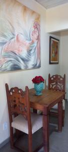 a dining room table with a vase of flowers on it at Suite em Lumiar in Lumiar