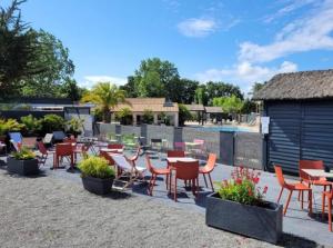 a patio with tables and chairs and a pool at La casa du clos in La Bernerie-en-Retz