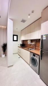 a kitchen with a washing machine and a sink at الزاوية للشقق الفندقية in Medina
