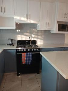 a kitchen with a black stove and white cabinets at Turtle Bay in Bridgetown