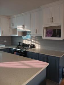 a kitchen with white cabinets and a stove top oven at Turtle Bay in Bridgetown