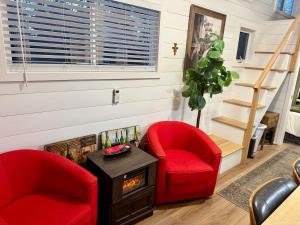 two red chairs in a living room with a staircase at Horseshoe Tiny home in Scottsdale