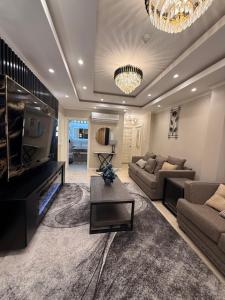 a living room with a couch and a tv at Lumiere Suites in Georgetown