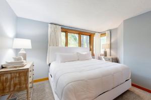 a white bedroom with a large bed and a window at Samoset Vacation in Gilford +18 photos
