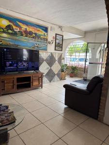 a living room with a couch and a flat screen tv at Hotel orla House in Petrolina