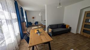 a living room with a wooden table and a couch at Statek Osmička in Dolní Hořice