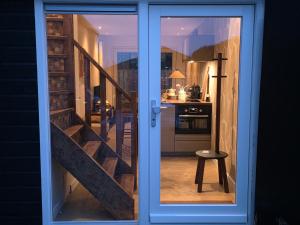 a glass door leading to a kitchen with a staircase at Riekje in Lage Zwaluwe +12 photos