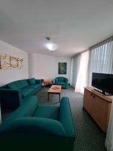 a living room with blue couches and a flat screen tv at Hotel Chacao Cumberland in Caracas