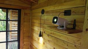 a room in a wooden cabin with a light on the wall at Cabaña Silencio en Casa Ilusión in Guarne