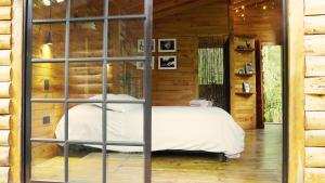 a bedroom with a bed in a log cabin at Cabaña Silencio en Casa Ilusión in Guarne