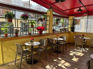 a restaurant with tables and chairs and windows at MARION HOTEL in Tirana