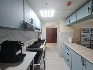 a kitchen with blue cabinets and a stove top oven at Belstay2 in Ras al Khaimah