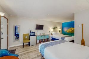 a hotel room with two beds and a desk at Lamplighter Inn - 115 Turtle Bay in Bandon