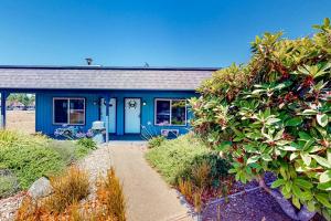 a house with a blue door and some bushes at Lamplighter Inn - 115 Turtle Bay in Bandon