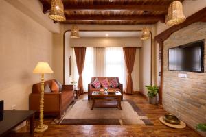 a living room with a couch and a tv at Temple Bell Boutique Hotel & Spa in Pokhara