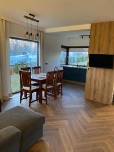 a living room with a table and chairs and a kitchen at Białe Żagle Mazury in Węgorzewo