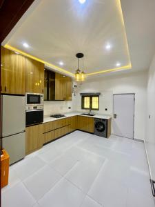 a kitchen with white floors and wooden cabinets at Luxury Four Bedroom Duplex in Asokoro Abuja in a Secure Estate with Fast WiFi & 24hours Electricity in Asokoro
