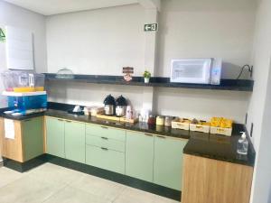 a kitchen with a counter top with a microwave at Hotel Pousadas Club Centro in Sorocaba