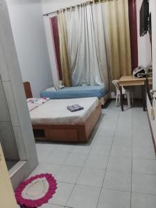 a room with two beds and a table and a desk at Hotel Baguari in São Paulo