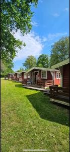 a row of cottages with a person standing on the porch at Sikhall Camping & Restaurang in Sörbo