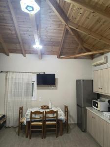 a kitchen with a table with chairs and a refrigerator at Avocado house in Finikounta