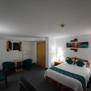 a hotel room with a large bed and a desk at Hotel Chacao Cumberland in Caracas