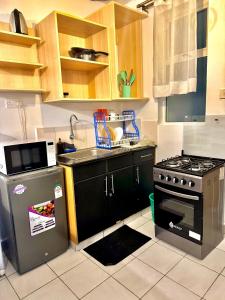 a kitchen with a stove and a sink at Sunstone Studio- Ngong Rd Near Junction Mall in Nairobi