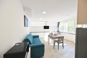 a living room with a blue couch and a table at Lucia Appartamenti in Ischia Town