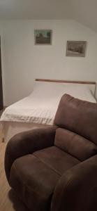 a brown couch sitting in front of a bed at Tisovecký apartmán in Tisovec