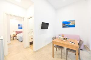 a living room with a table and a room with a bed at Lucia Appartamenti in Ischia Town +21 photos