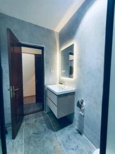 a bathroom with a sink and a mirror at Volidam Hotel in Qarshi