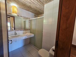 a bathroom with a sink and a toilet and a mirror at Hotel Pousada Imbassai in Imbassai +31 photos