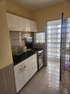 a kitchen with white cabinets and a stove top oven at Apart Rucapel in General Roca