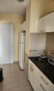 a kitchen with a sink and a refrigerator at Apart Rucapel in General Roca