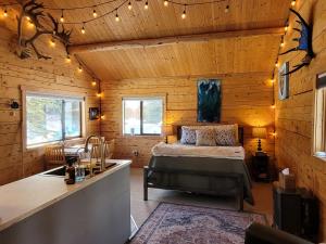 a bedroom with a bed in a wooden cabin at Little Bear Getaway Cabins in Glacier View