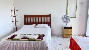 a bedroom with a bed with a fan and a dresser at Suítes FM in Cavalcante