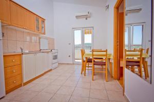 une cuisine avec une table et des chaises ainsi qu'une salle à manger dans l'établissement Apartment Mara, à Primošten