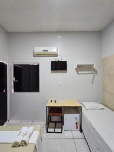 a hospital room with two beds and a desk at Canto da Duna Hotel in Barreirinhas