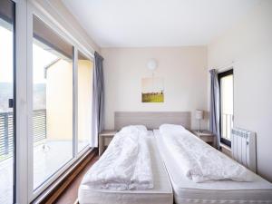 a bedroom with two beds and a large window at Hambachtal nature hideaway boutique resort in Oberhambach +32 photos