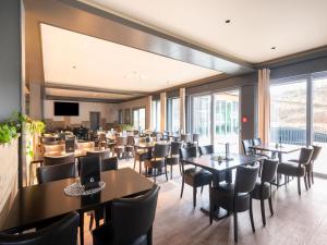 a restaurant with tables and chairs and a large window at Hambachtal nature hideaway boutique resort in Oberhambach