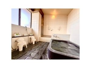 a bathroom with a tub and a toilet and a sink at Royal Hotel Uohachi - Vacation STAY 71042v in Toyota +33 photos