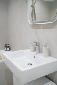 a white bathroom with a sink and a mirror at Modernes Apartment in Schwechat in Schwechat