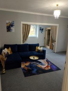 a living room with a blue couch and a surfboard on a rug at Mia Apartman Salgótarján in Salgótarján