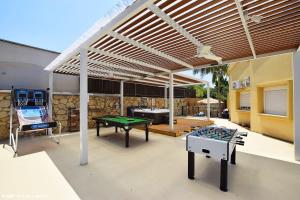 a pergola with a ping pong table and a ping pong table at וילה ארבל in Kefar Weradim