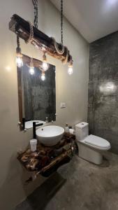 a bathroom with a white sink and a toilet at Ginhawa Stay Private Pool Studio in Burgos +9 photos