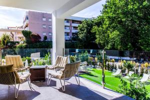トレモリノスにあるDimona Suites Apartamentos Turísticosの庭園の景色を望むパティオ(椅子付)