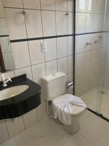 a bathroom with a toilet and a sink at Hotel Sara - Ampere in Ampère